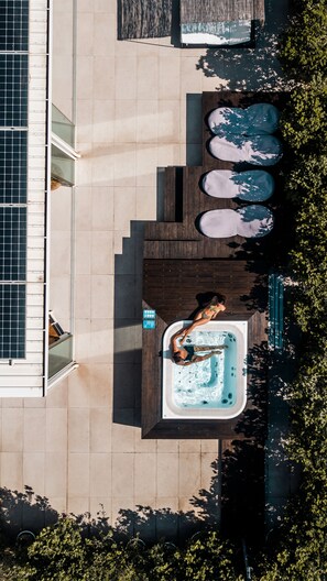 An aerial view of a rooftop pool area with a hot tub, wooden deck, and solar panels. - Alkamuri Posh Hotel & Spa (Alcamo)