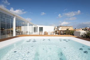 Una piscina al aire libre, sillones reclinables de piscina