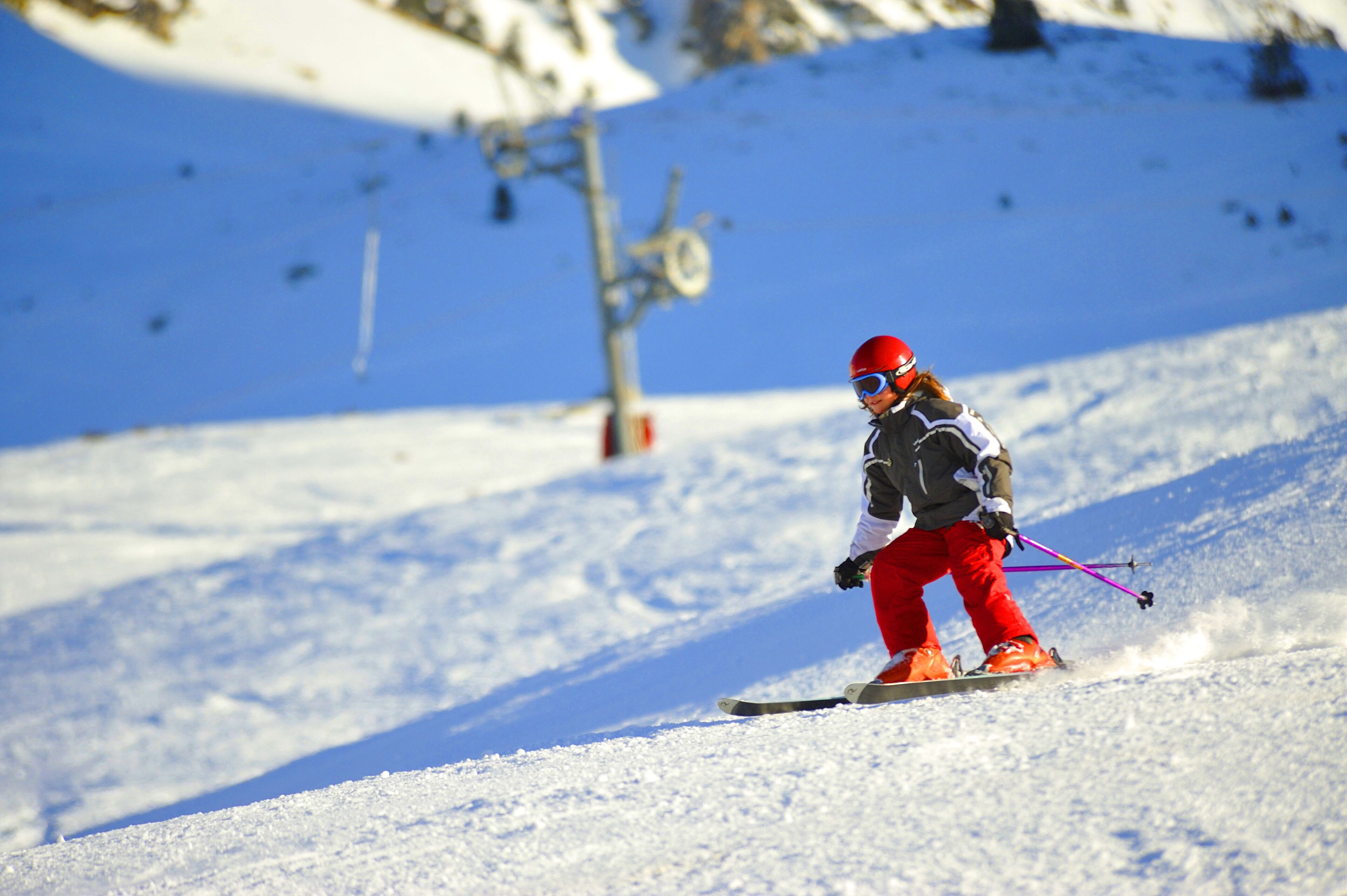 Une personne qui fait du ski sur une pente enneigée.