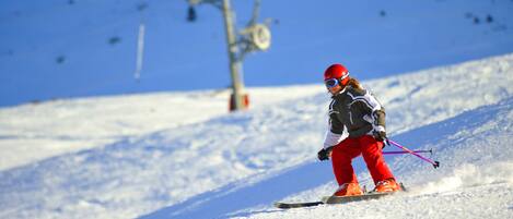 Une personne qui fait du ski sur une pente enneigée.