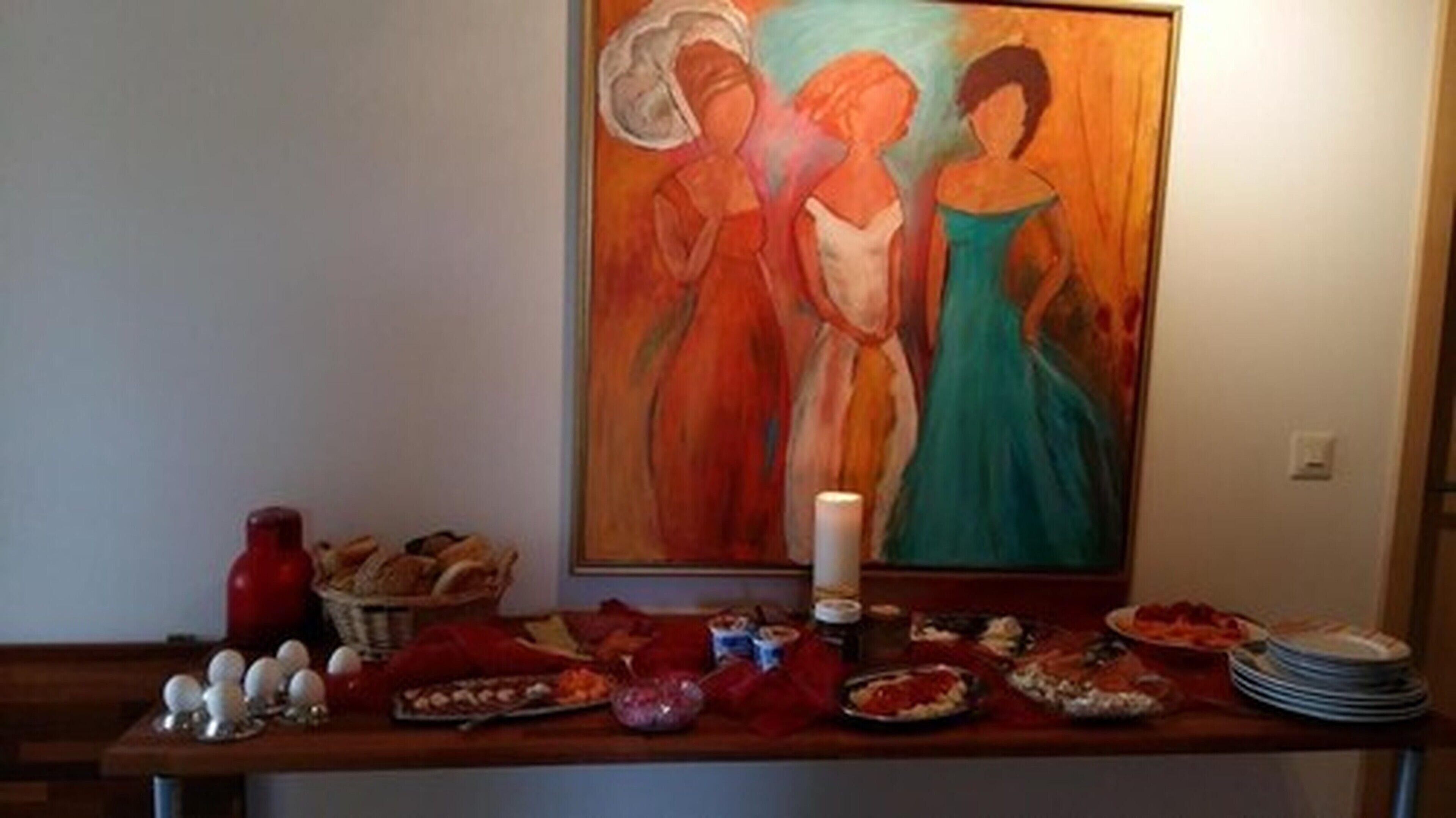 Een eettafel met verschillende gerechten en een schilderij aan de muur.