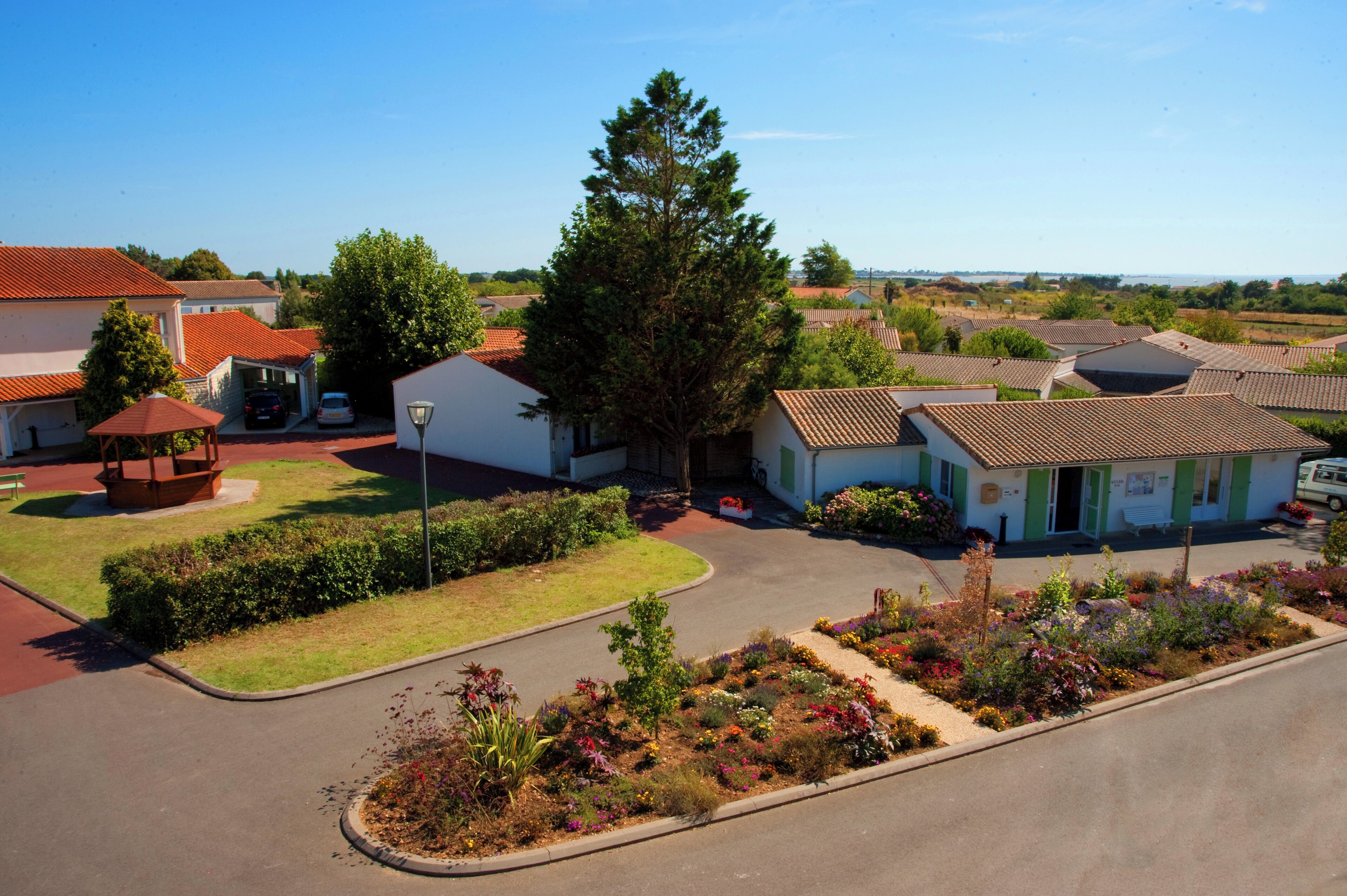 A residential area with houses, a gazebo, and a well-maintained garden.