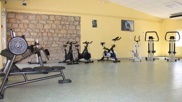 A gym with various exercise equipment, including treadmills, stationary bikes, and weight machines.