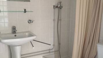 A bathroom with a sink, toilet, shower, and bathtub.