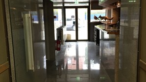 Un pasillo con una puerta de cristal que da a un estacionamiento.