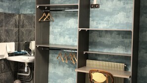 Un baño con lavabo, espejo y barra para toallas. Cuenta con un radiador y una silla.