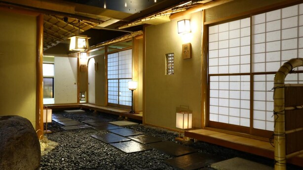 A traditional Japanese interior with tatami flooring, sliding doors, and low lighting. - TOKIWAYA Ryokan (Nozawaonsen)