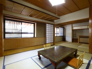A traditional Japanese room with tatami flooring, a low wooden table, and sliding doors. - TOKIWAYA Ryokan (Nozawaonsen)