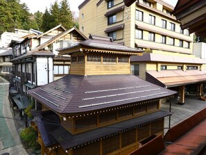 A traditional Japanese building with a wooden structure and a dark tiled roof.