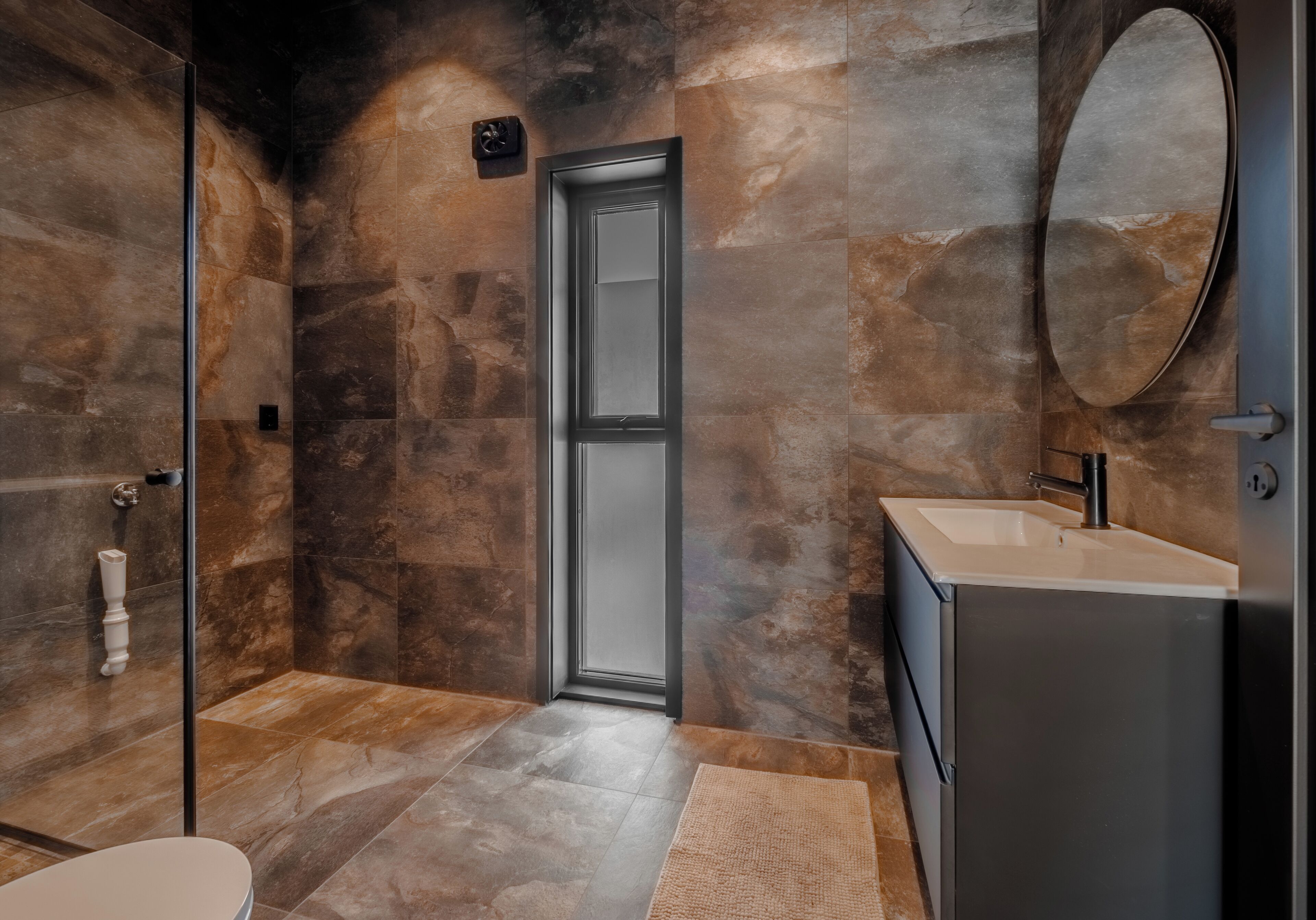 Une salle de bain moderne avec une douche à parois de verre, un lavabo et un miroir.