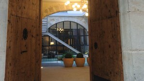A wooden entrance with a sign indicating a fire exit, a staircase, and potted plants. - Mon Suites San Nicolas (Valencia)