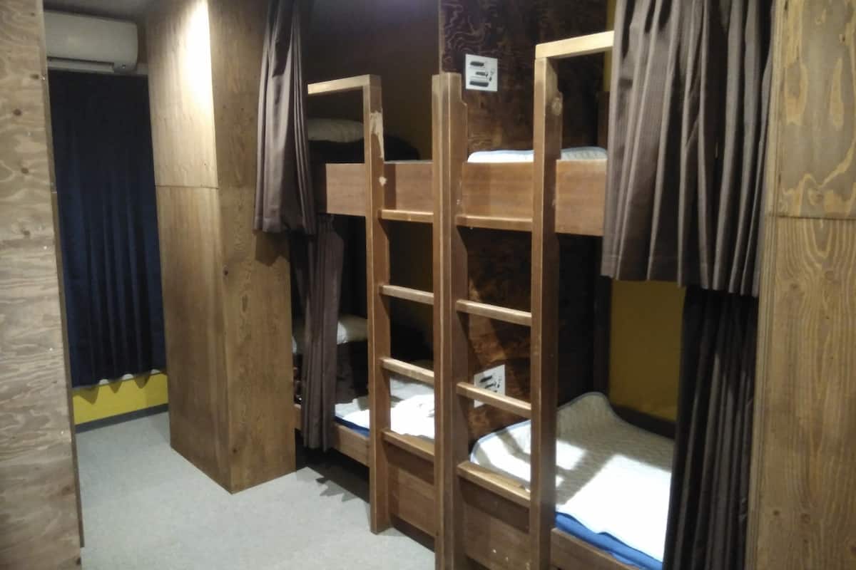 Habitación con literas, paredes de madera y una lámpara en el techo.
