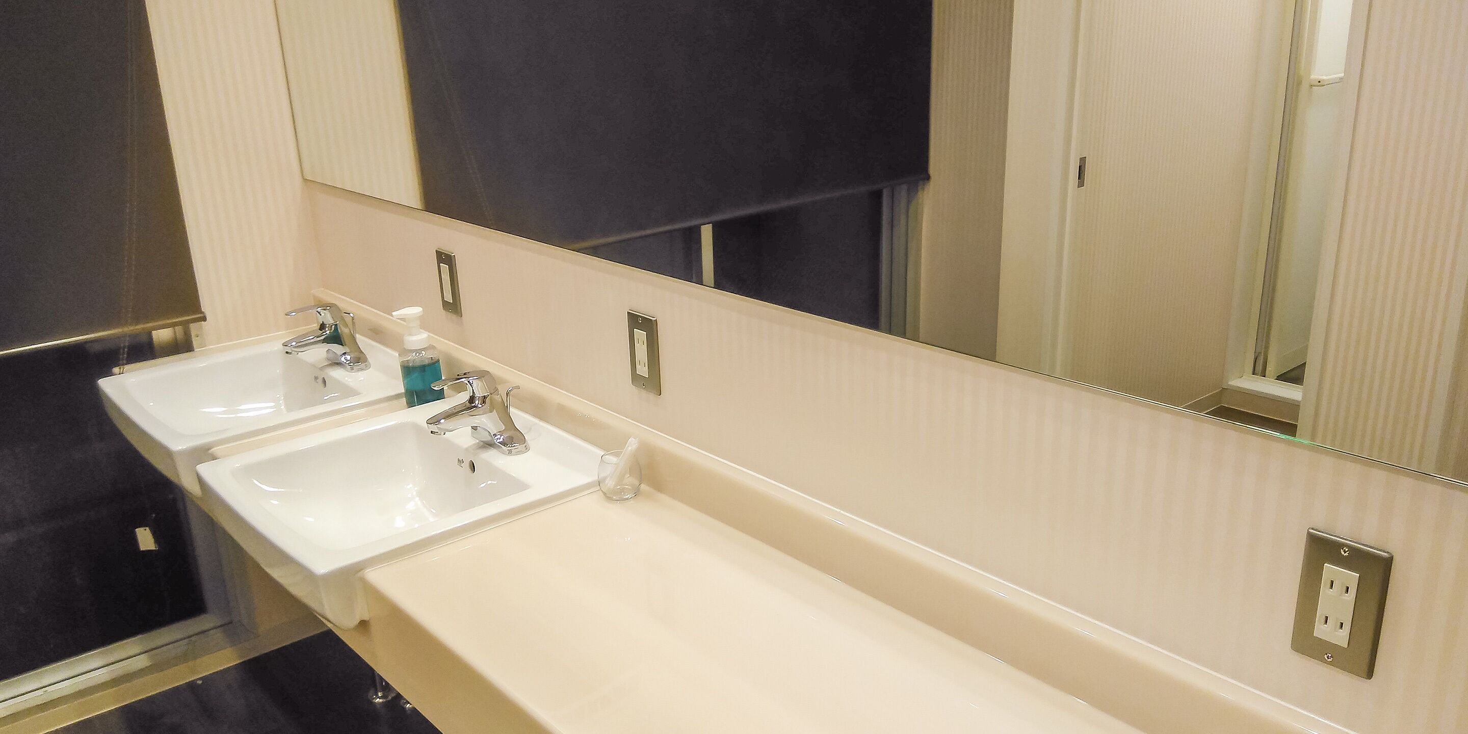 A bathroom with two sinks, a mirror, and a towel rack.