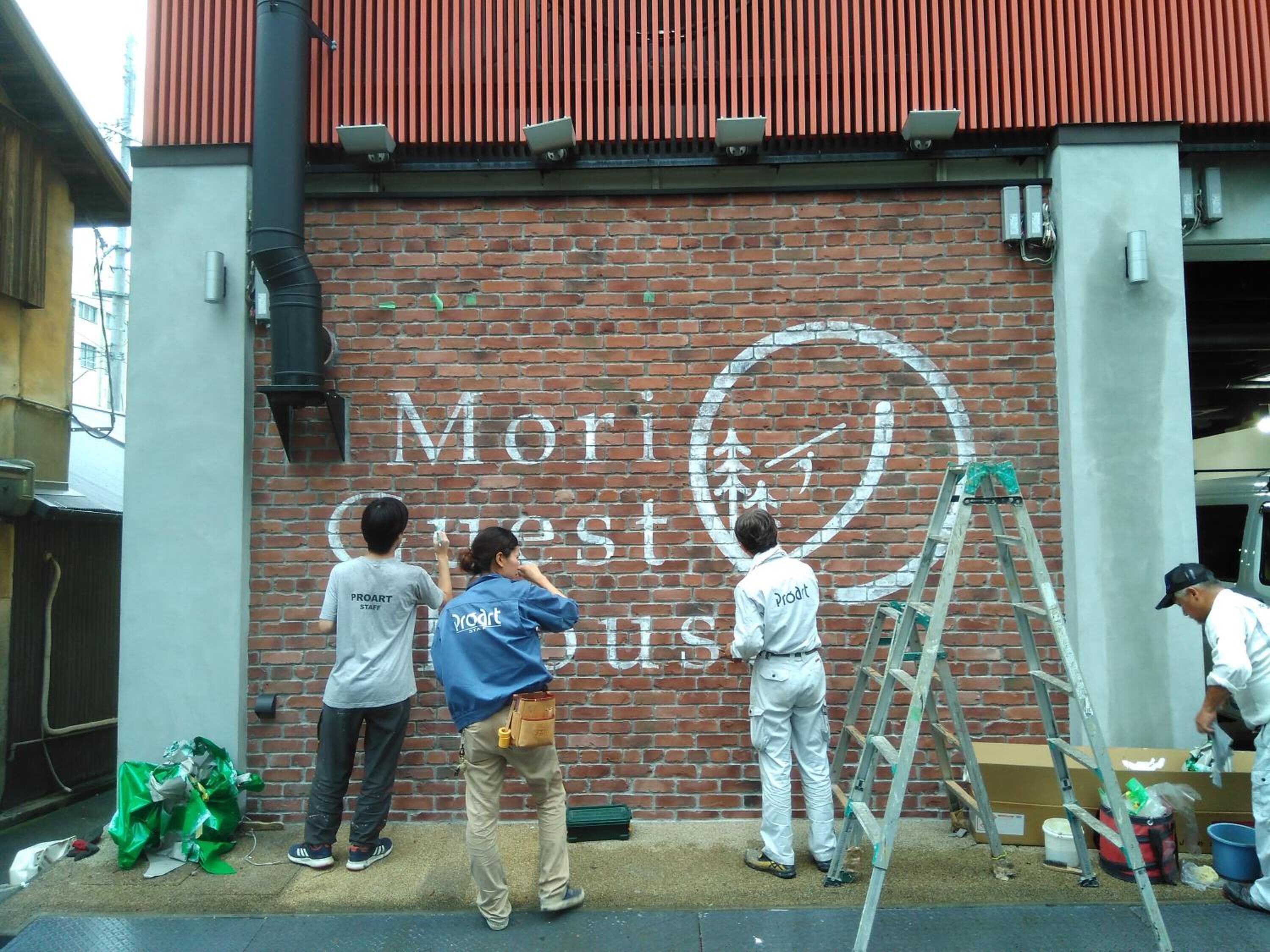 Un muro de ladrillo con un mural de una bicicleta y el texto "Mori West Bus".