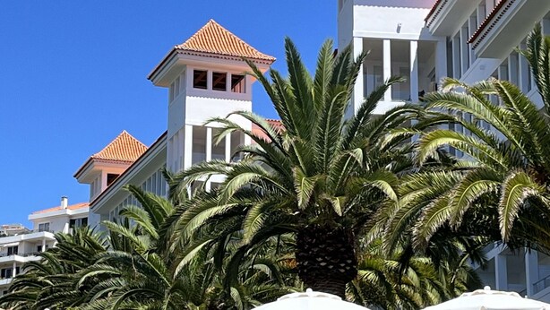 A hotel with multiple white buildings featuring red-tiled roofs and a clear blue sky. - Penthouse Caniço de Baixo (Santa Cruz)
