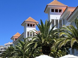 Un hotel con varias edificaciones blancas y techos de tejas rojas bajo un cielo azul despejado.