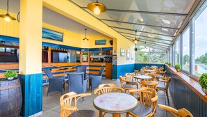 Ein Restaurant mit Bar, Sitzgelegenheiten und großen Fenstern.