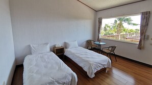 A room with two single beds, a small table, two chairs, and a window with a view of palm trees. - Dulan Red House (Donghe)
