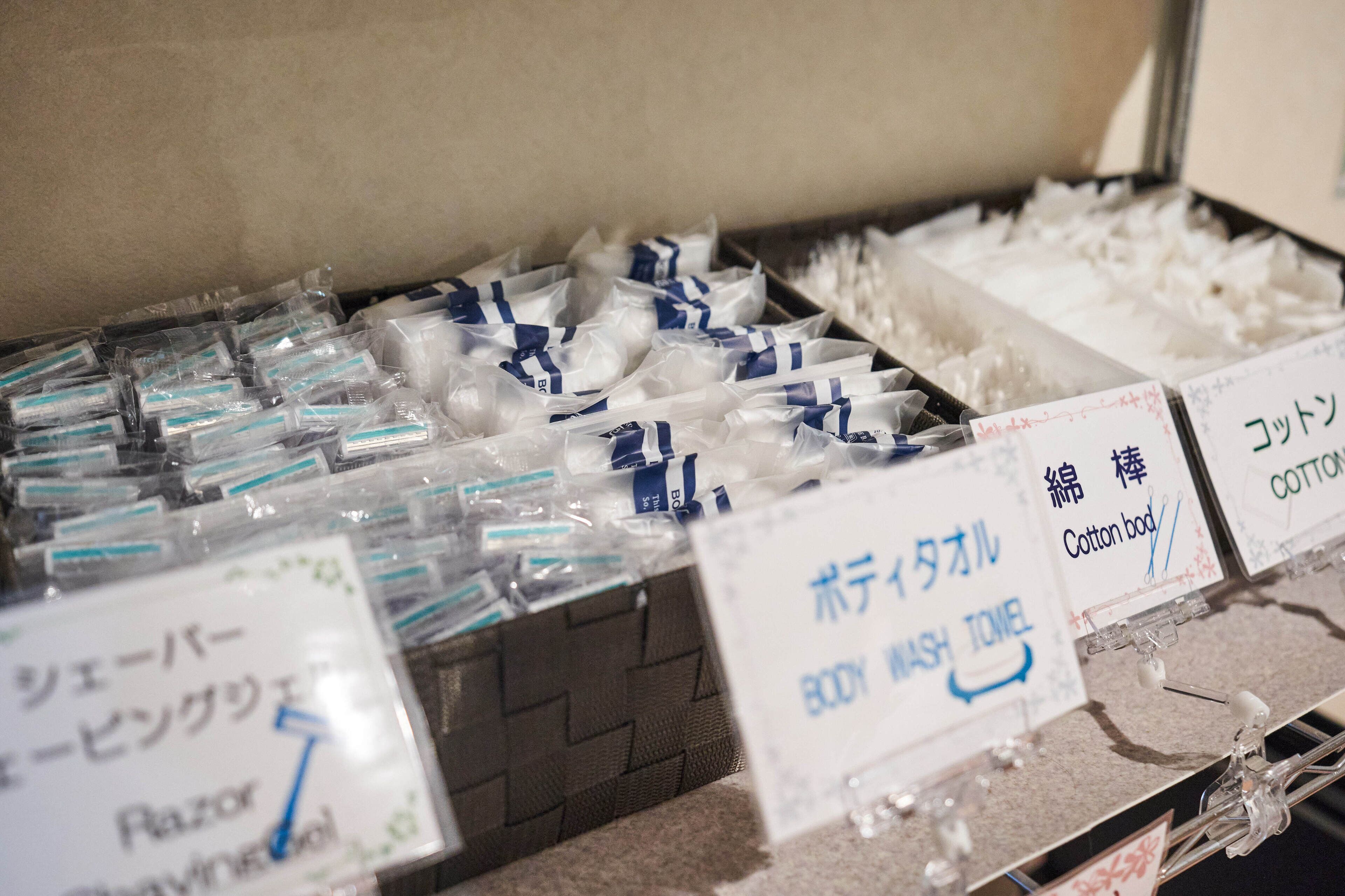 A display of packaged goods with labels indicating items like razors and cotton buds.