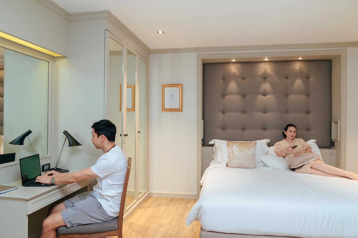 Ein Schlafzimmer mit einem Bett, einem Schreibtisch mit einem Laptop und einem Stuhl.