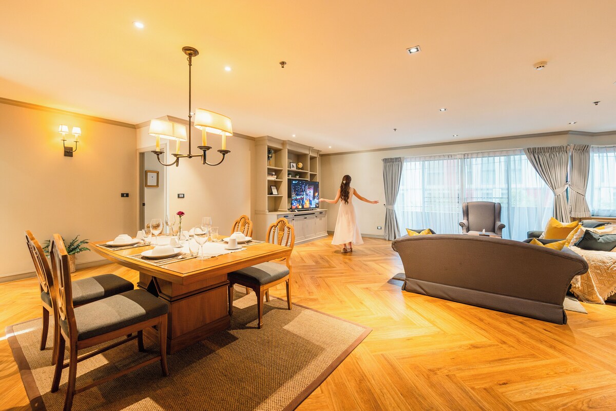 A spacious living room with a dining area, a sofa, and a TV.