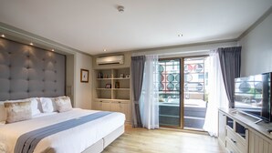 Ett sovrum med en stor säng, inbyggda hyllor, en luftkonditioneringsanläggning och en tv.