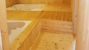 Un sauna de madera con dos zonas de baño separadas y suelo de madera.