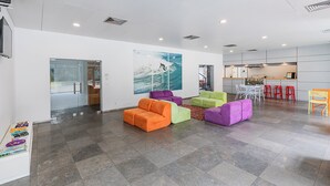 A modern interior with a seating area, a kitchen, and a view through a glass door.