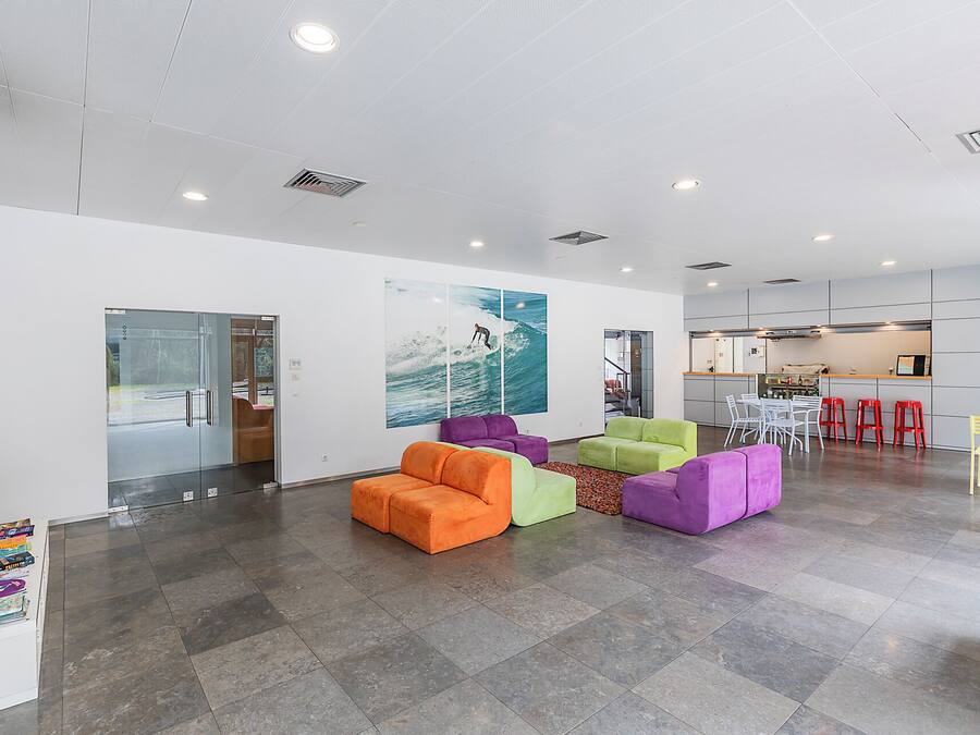 Ein modernes Interieur mit einer Sitzecke, einer Küche und Blick durch eine Glastür.