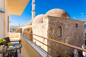 A balcony with a view of a mosque with two domes and a minaret. - Polyxenia Suites (Rethymno)
