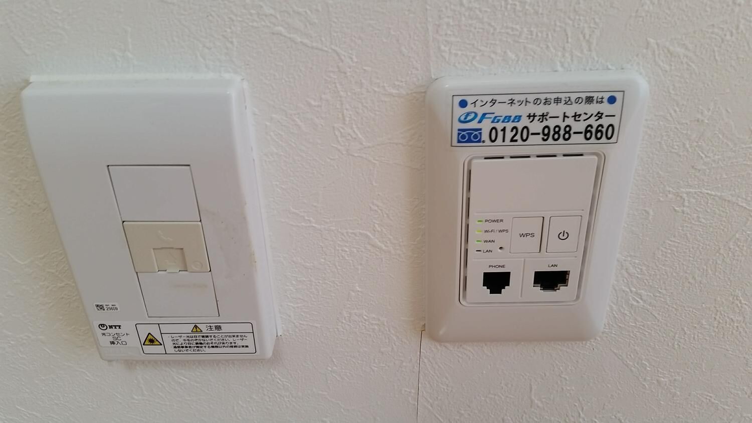 Um interruptor de tomada fixado na parede e um roteador de rede com etiqueta.