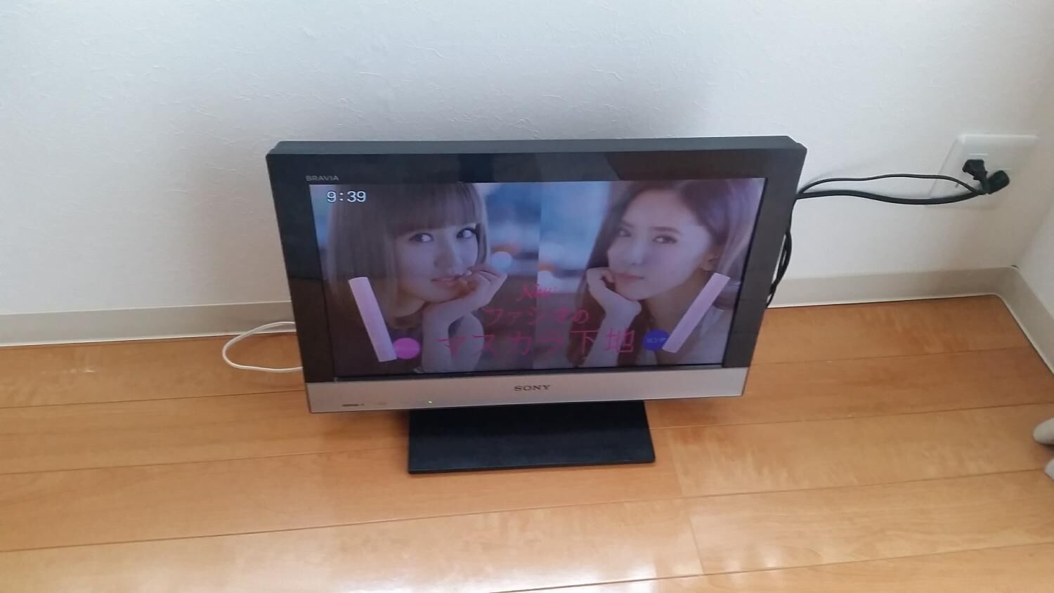 A Sony TV on a wooden floor with a white wall in the background.