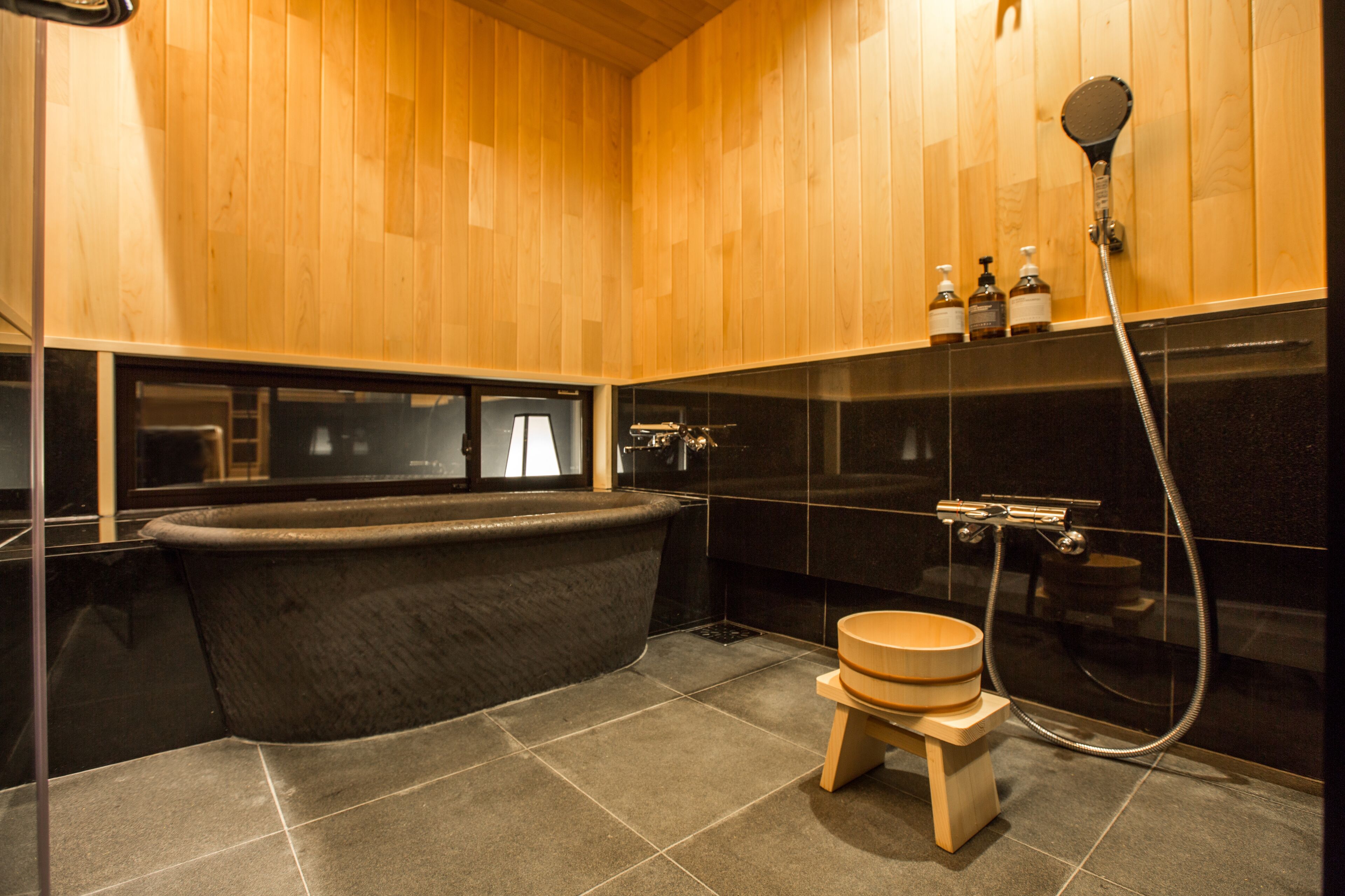 Une salle de bain moderne avec une baignoire sur pieds, des toilettes en bois et un espace douche.