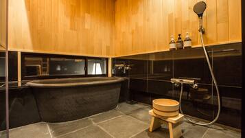 Une salle de bain moderne avec une baignoire sur pieds, des toilettes en bois et un espace douche.