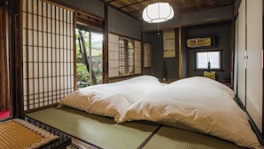 A traditional Japanese room with tatami flooring, a low ceiling, and sliding doors. - Temple Hotel Takayama Zenkoji (Takayama)