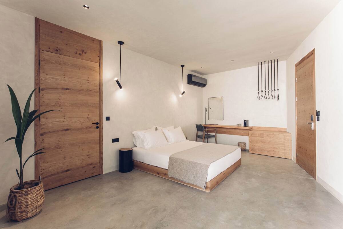 Un dormitorio moderno con una cama grande, un armario de madera y una zona de escritorio.