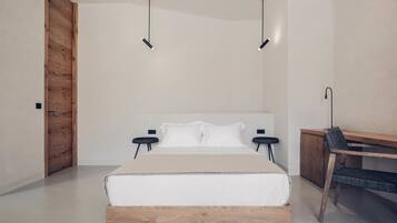 A modern bedroom with a large bed, bedside tables, a desk, and a chair.
