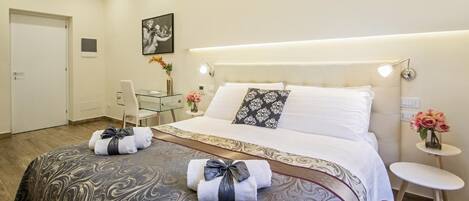 A hotel room with a large bed, bedside tables, a desk, and a chair.