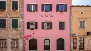 A pink building with the sign "Casa San Vito" and multiple windows with shutters. - Casa San Vito (Rijeka)