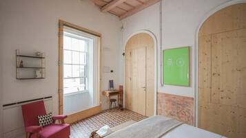 A room with a bed, a desk, a chair, and a green screen.