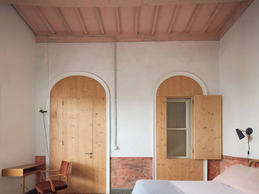 Un dormitorio con cama, escritorio, silla y armario.