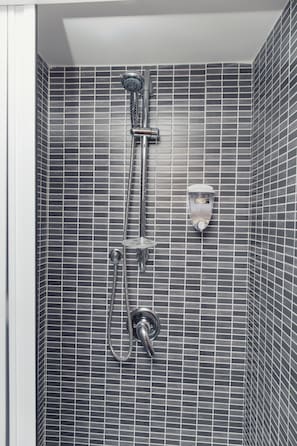 A shower with a handheld showerhead and a wall-mounted faucet, set against a tiled wall. - Palazzo Carafa della Spina - Charme (Naples)