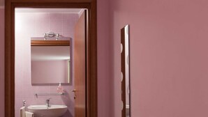 A bathroom with a sink, mirror, and a towel rack.