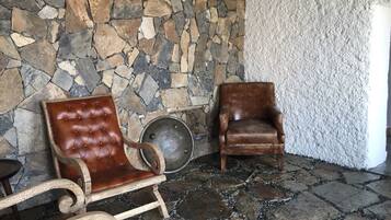 A stone wall with two leather chairs and a metal plate.