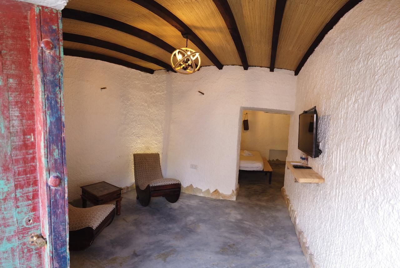 Ein Zimmer mit schrägem Dach, einem an der Wand montierten Fernseher und einem kleinen Tisch.