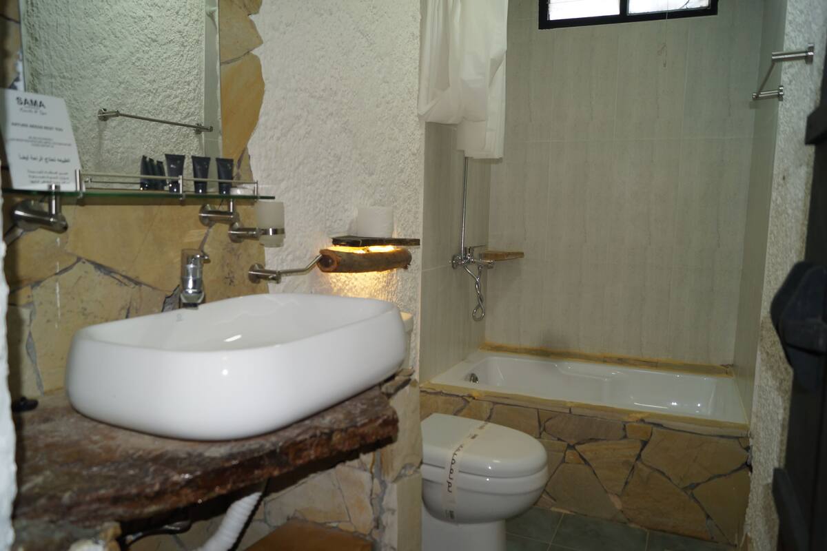 Un baño con lavamanos de piedra, bañera y retrete.