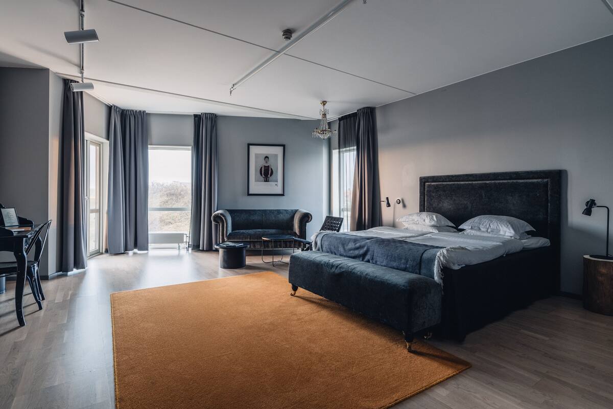Un dormitorio moderno con una cama grande, un escritorio y una silla.