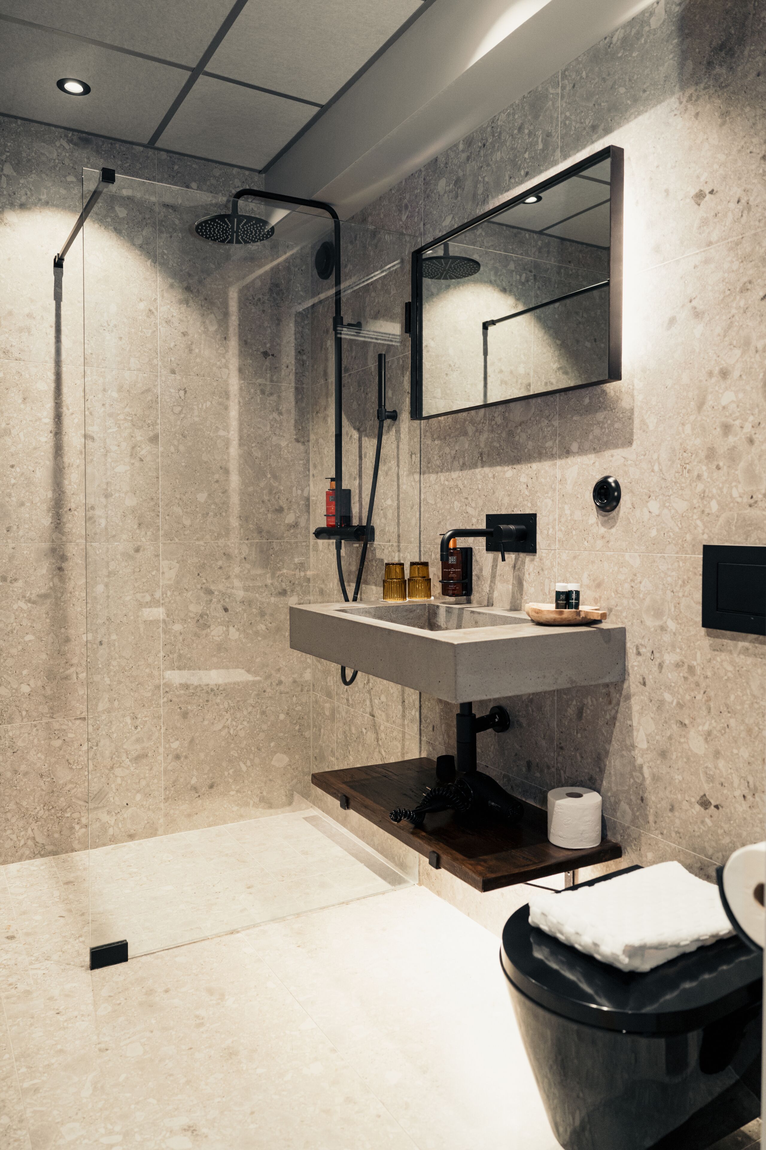 Un baño moderno con ducha, lavamanos e inodoro.