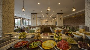 Un bufé con diversas frutas, verduras y quesos.