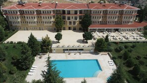 Experience the tranquil atmosphere of our central courtyard, featuring a swimming pool surrounded by lush greenery and comfortable outdoor seating areas.